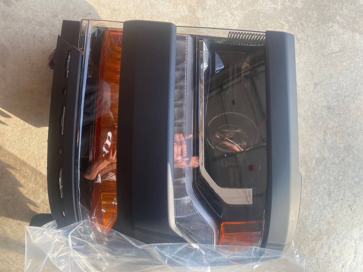 Packaged pair of black headlights with projector lens and amber turn/DRL lens