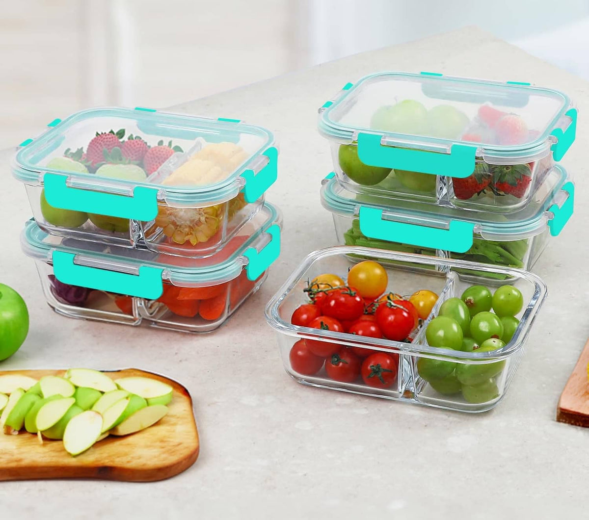 Clear glass 2-compartment meal prep bento boxes with teal latches, filled with produce