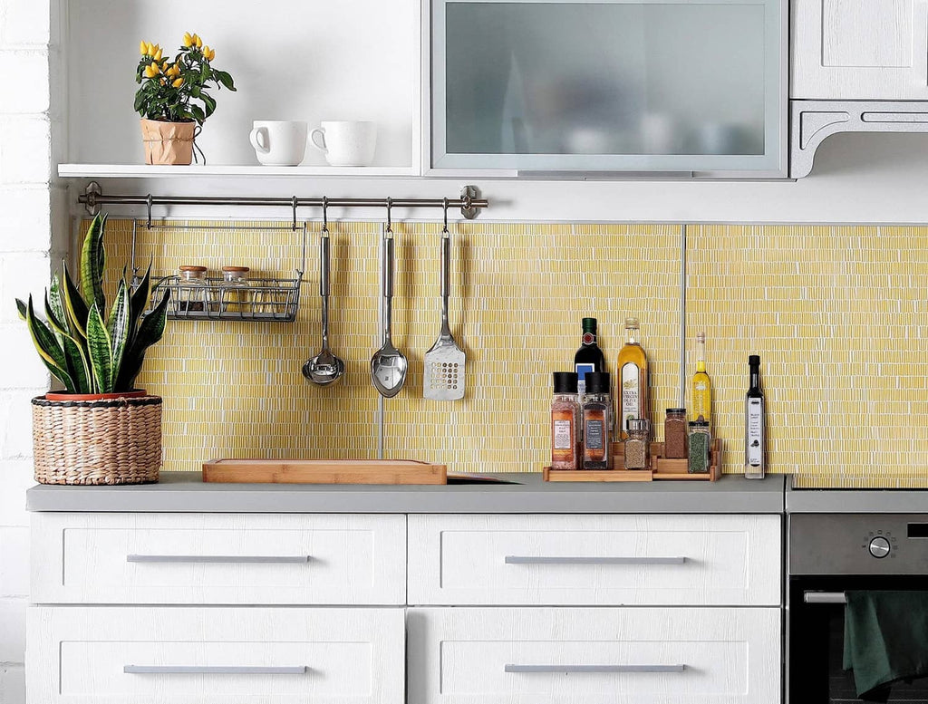 Wooden countertop cutting board with bottles and kitchen utensils nearby