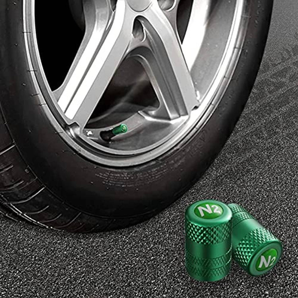 Green tire valve stem caps with N2 logo, placed near car wheel