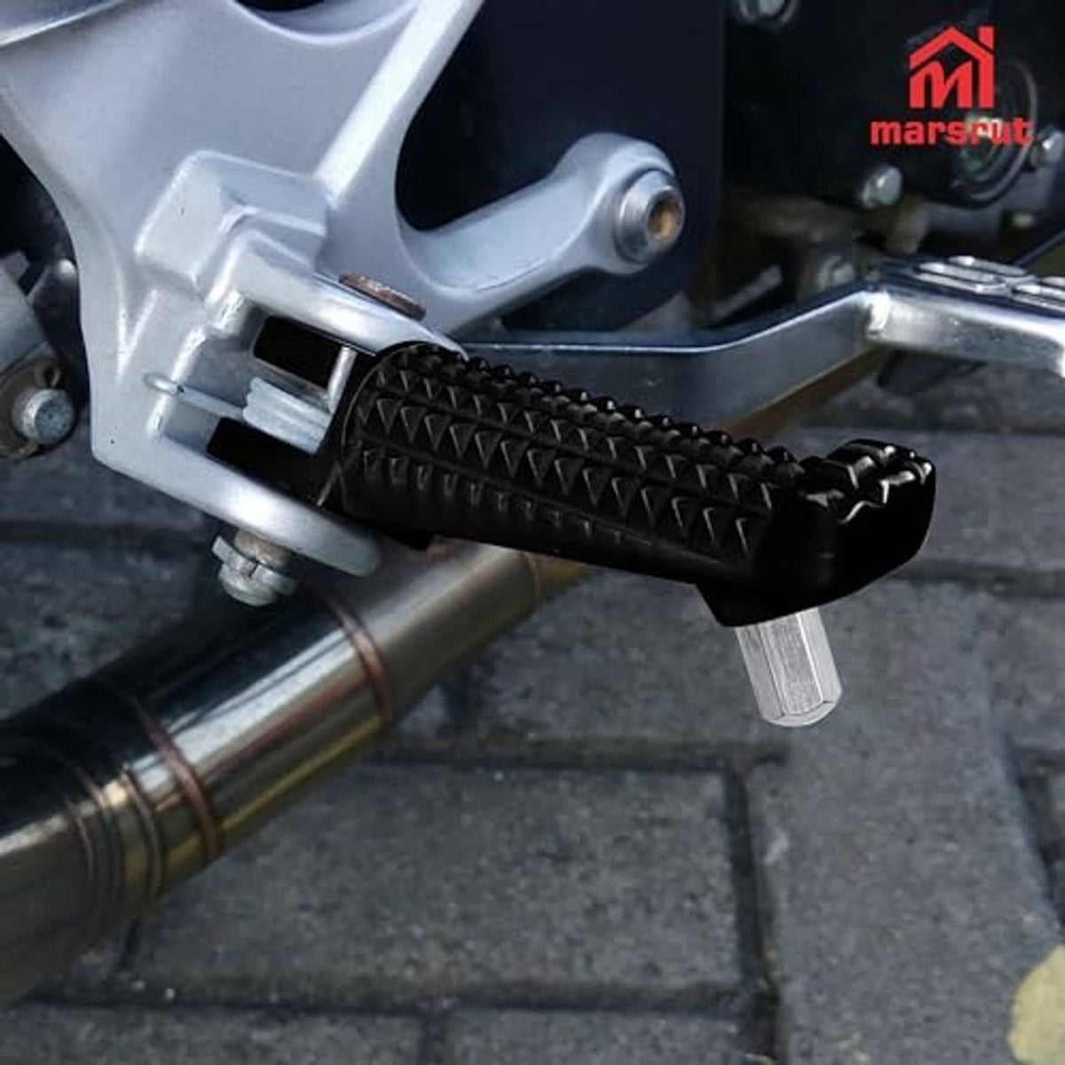 Front foot peg mounting bracket with textured black rubber grip on motorcycle