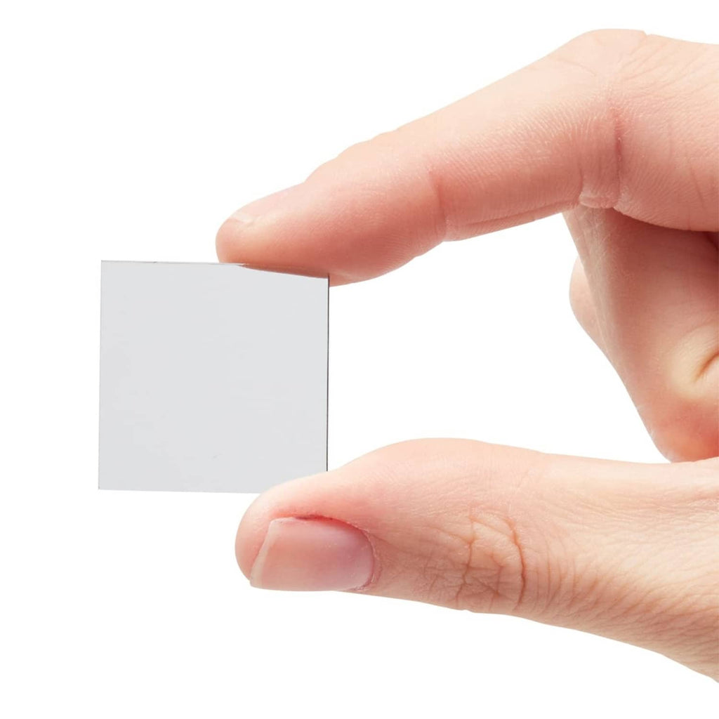 Single small square glass mirror tile held between fingers