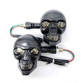 Pair of skull motorcycle turn signal lights with black housings, amber LEDs, and wired leads