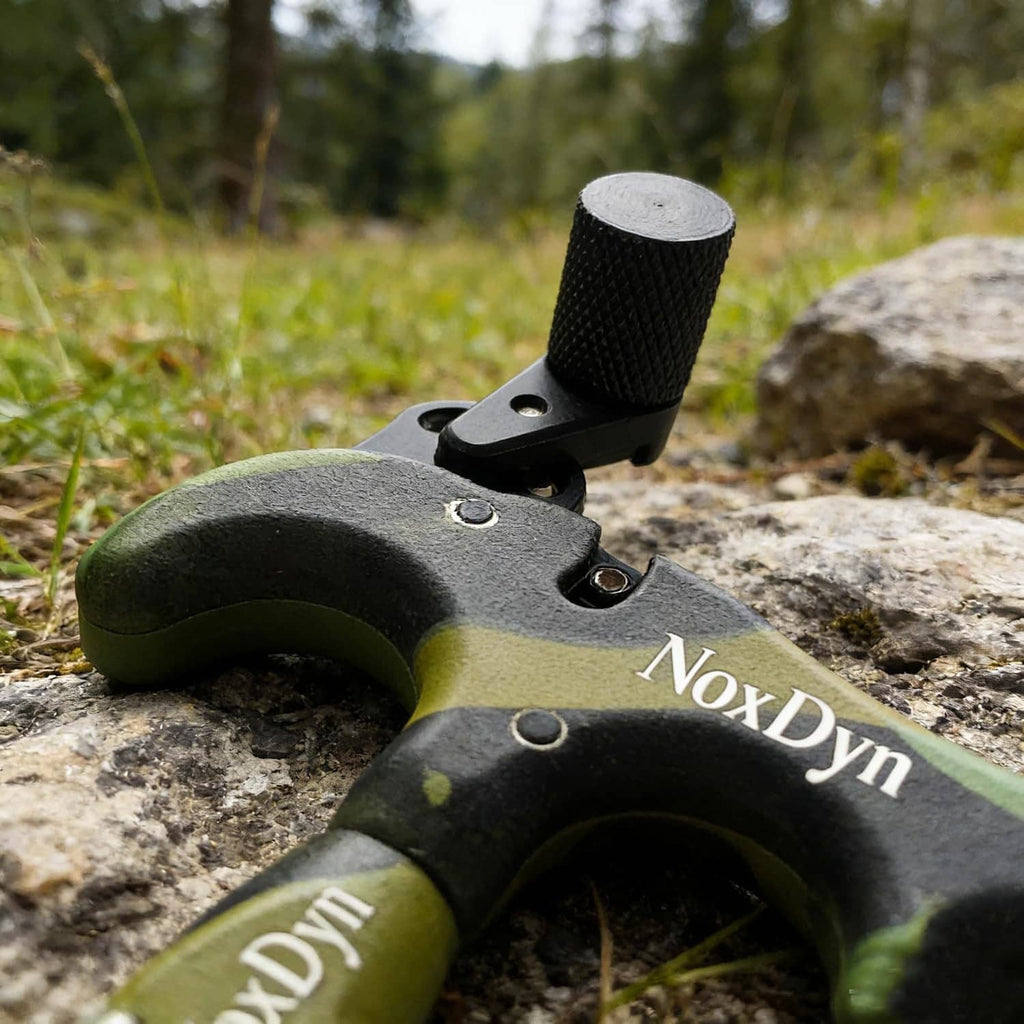 Archery thumb release on camo green/black body, black handle, NoxDyn metal jaw