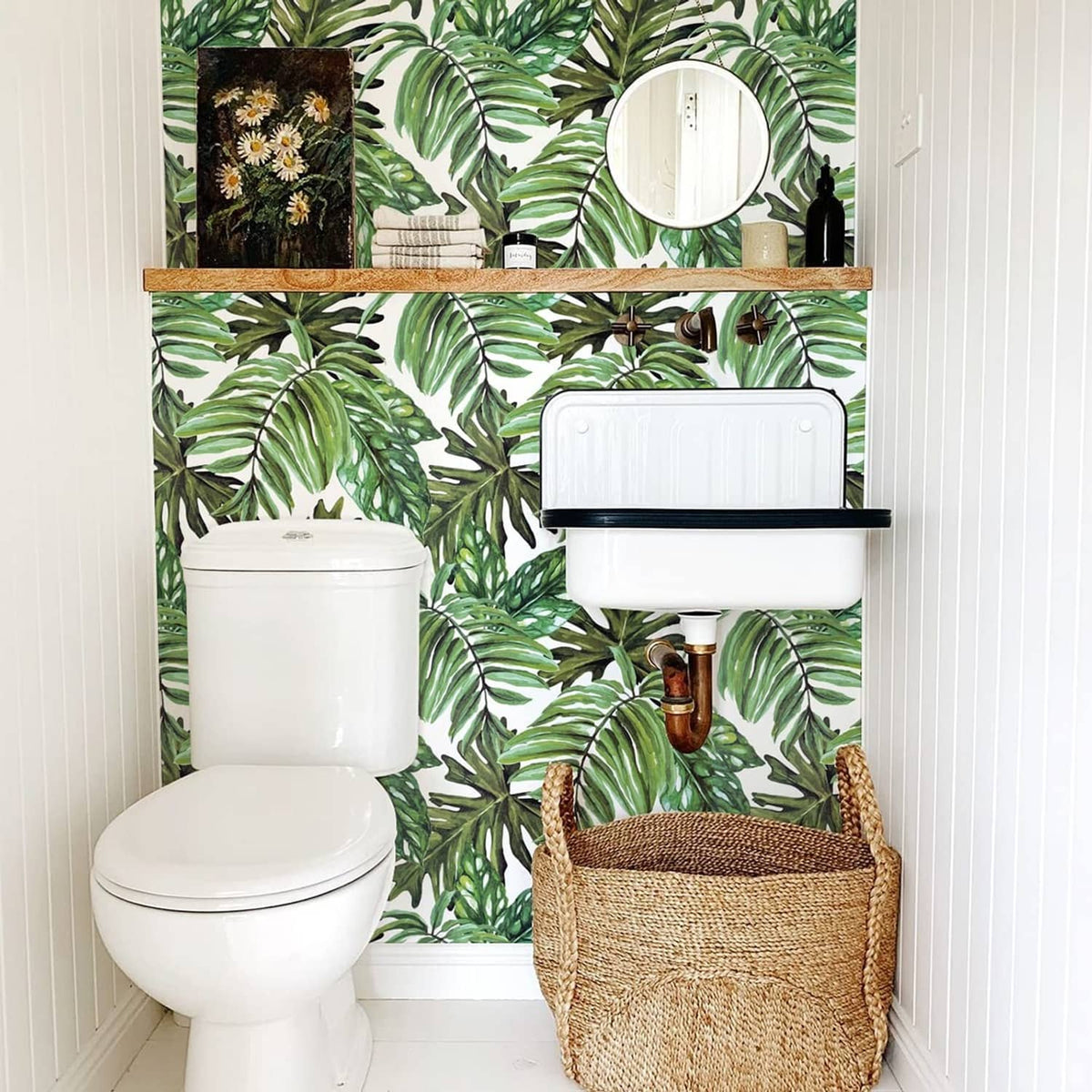 Tropical palm leaf peel-and-stick wallpaper on bathroom wall with green foliage design