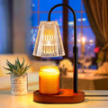 Electric candle warmer lamp with black stand and clear glass shade, warming a jar candle.
