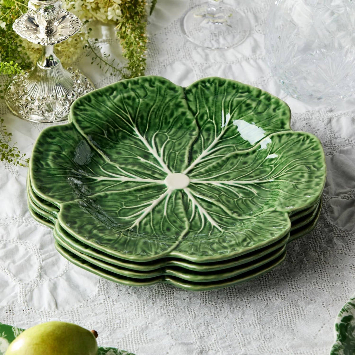 Stacked green cabbage dinner plates, set of four, bold white radial vein design.
