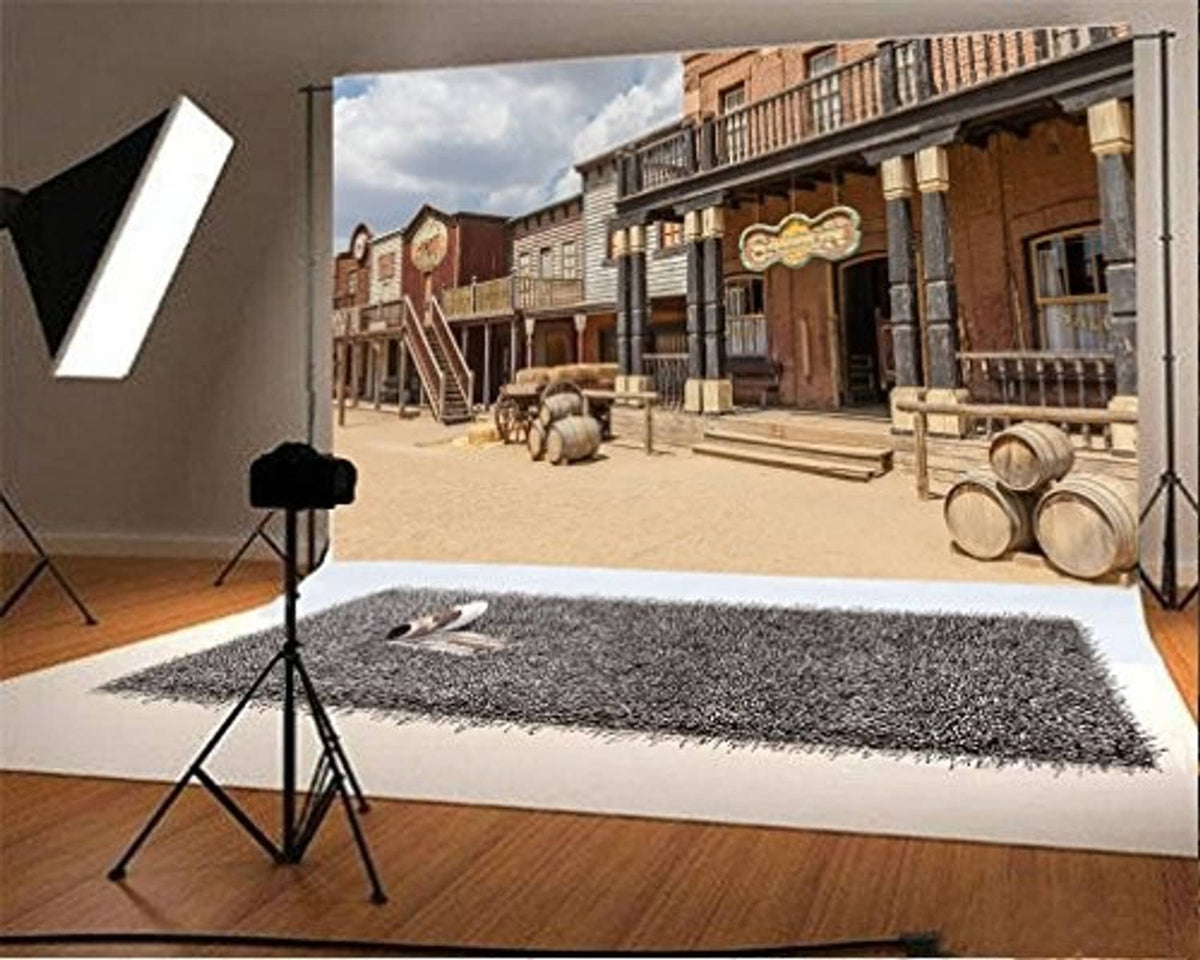 Western photo backdrop featuring storefronts, steps, and stacked barrels