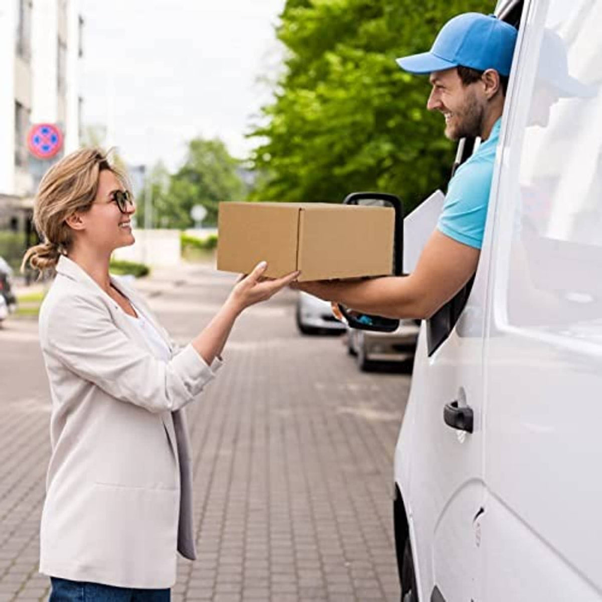 Corrugated shipping box held during delivery by a person at the door