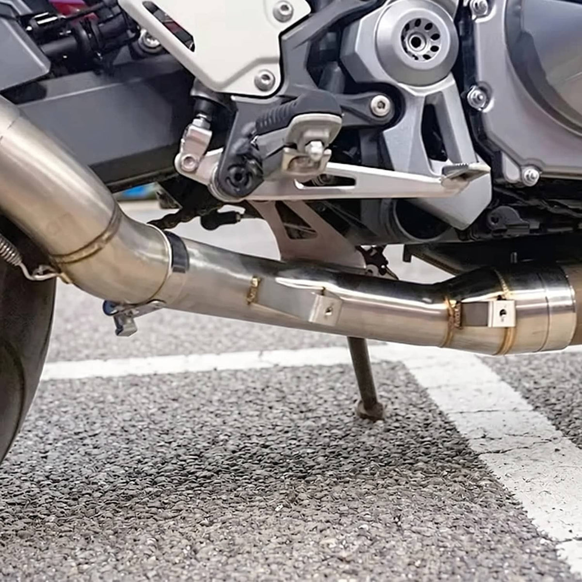 Stainless exhaust mid link pipe installed on motorcycle with mounting hardware