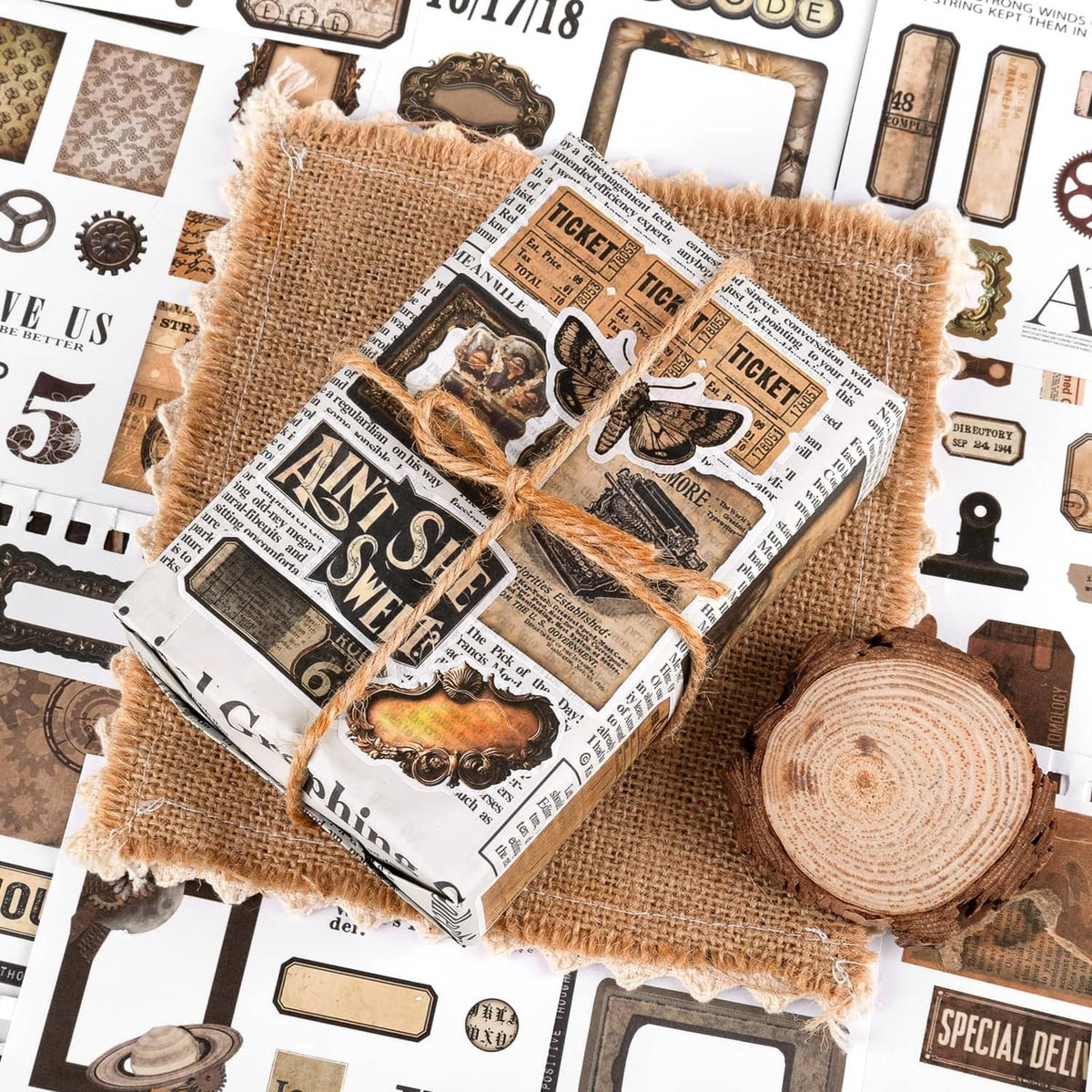 Vintage ephemera sticker bundle tied with twine over a background of ticket and tag stickers
