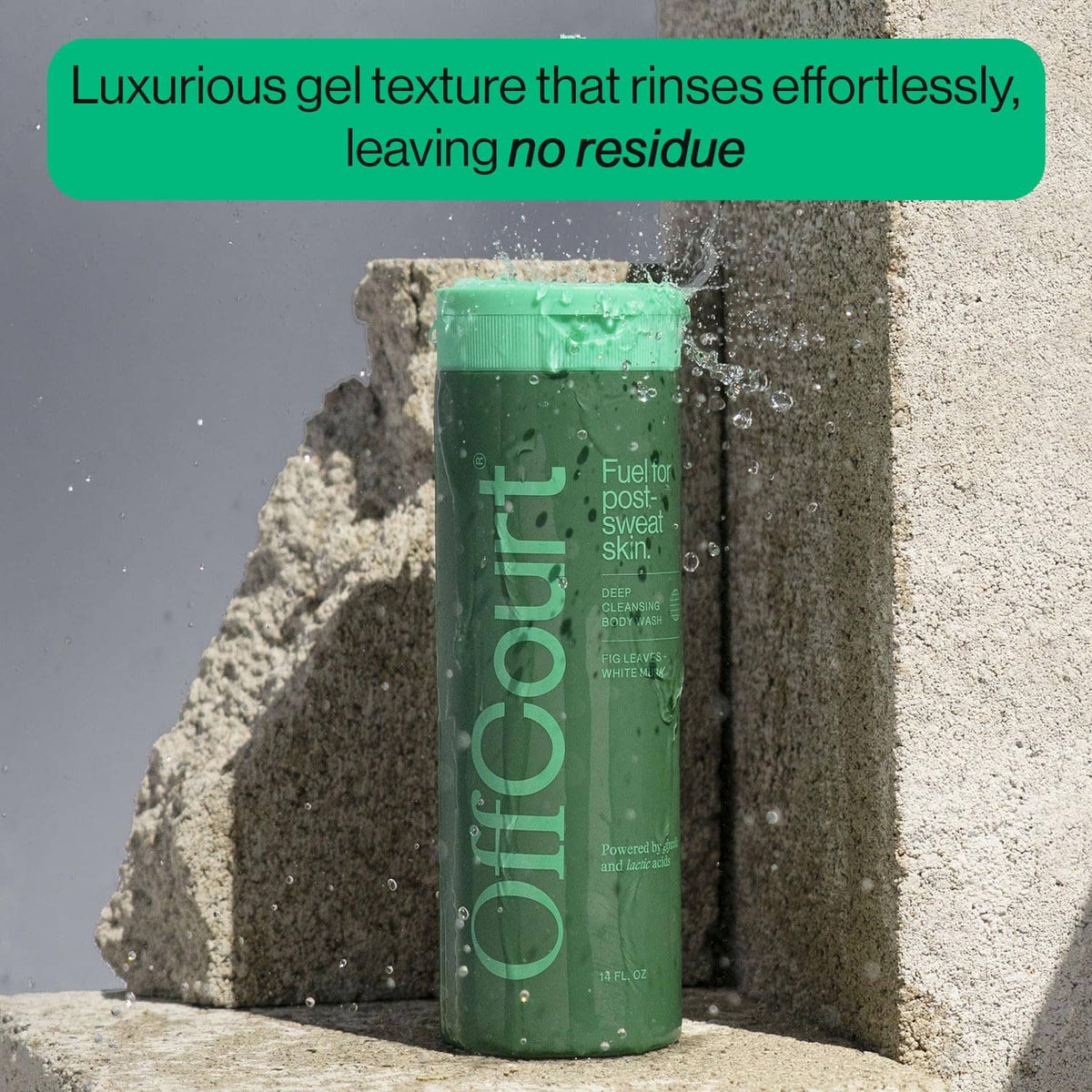 Offcourt green shower gel bottle standing on sandy rocks, 14 fl oz