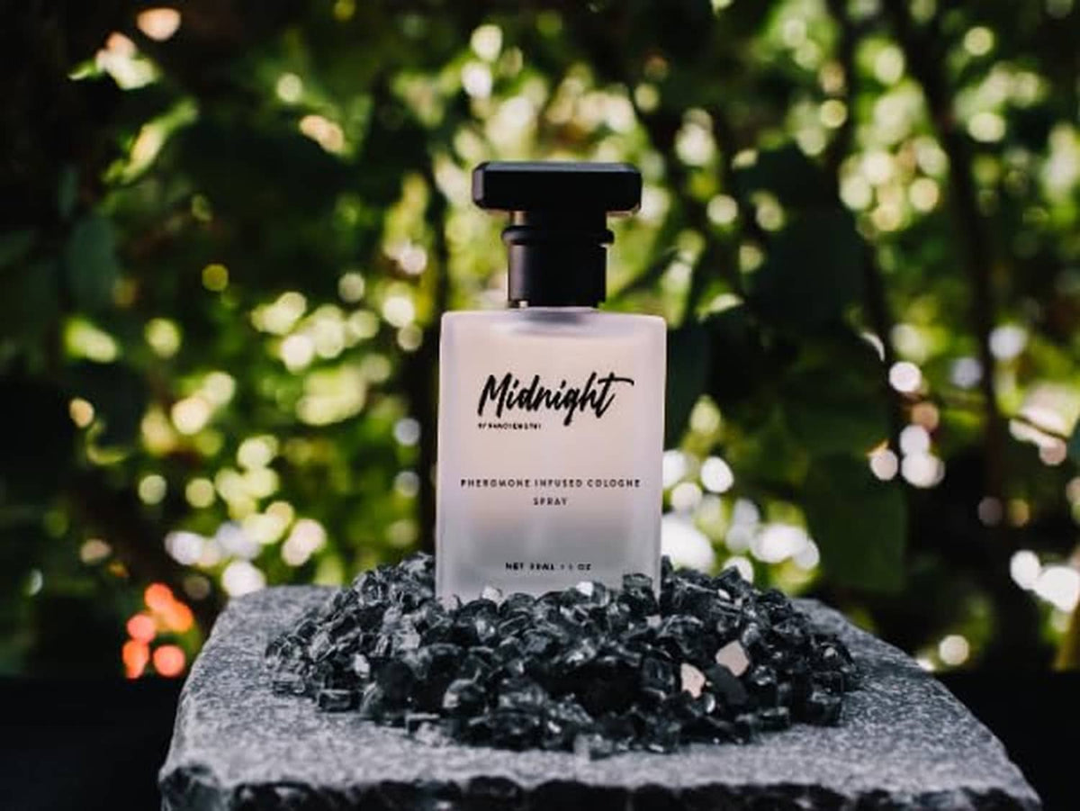 Cologne spray bottle with black cap on a rock