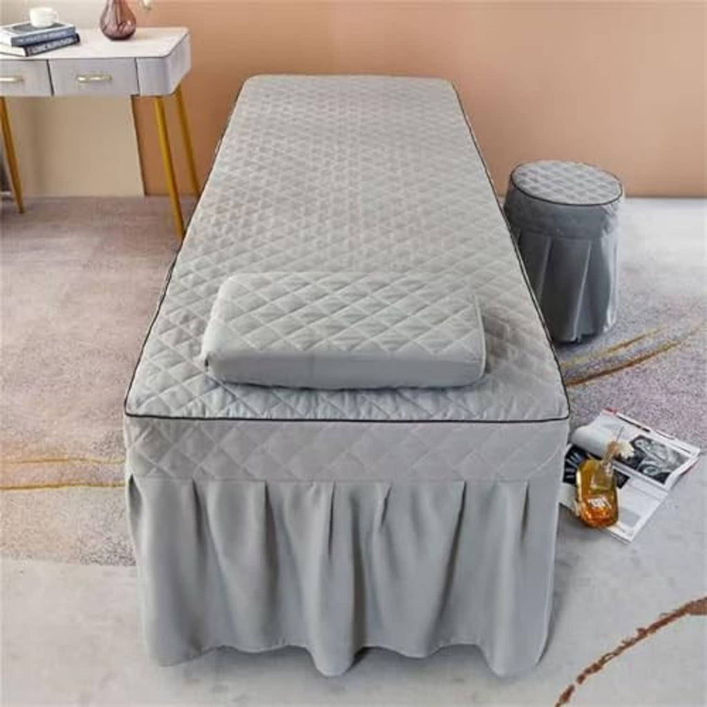 Grey quilted massage table skirt with pleated ruffle and fitted edges for coverage
