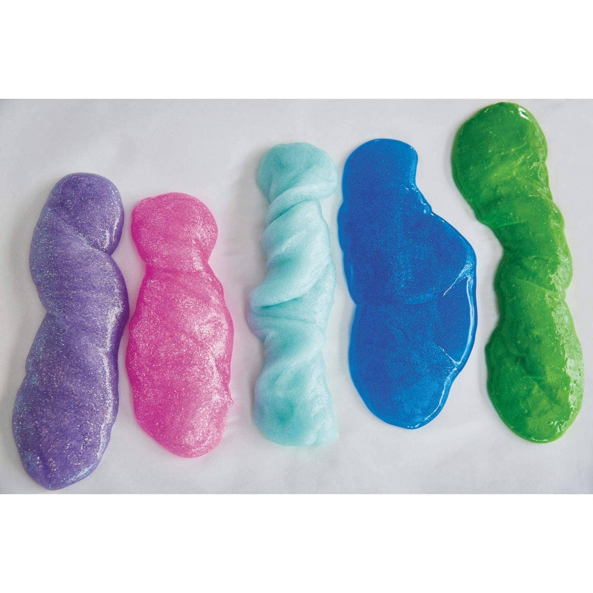 Colored slime samples on a surface: purple, pink, light blue, dark blue, green