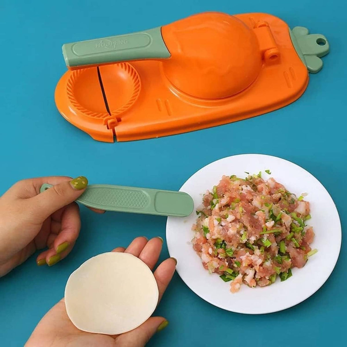 Orange dumpling press mold with green handle shaping a round dumpling on dough