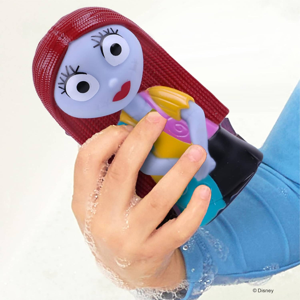 Close-up of child squeezing a jumbo bath squirter character during play