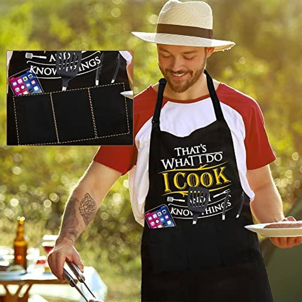 Black grilling apron worn by man, with 'I Cook' chest print and cross-back straps