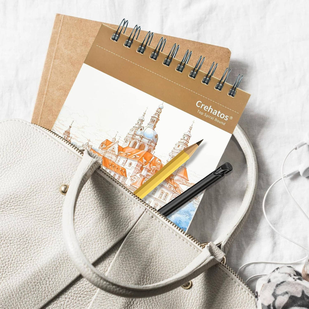 Sketch book with top spiral binding partially inside a light gray bag with pencils.