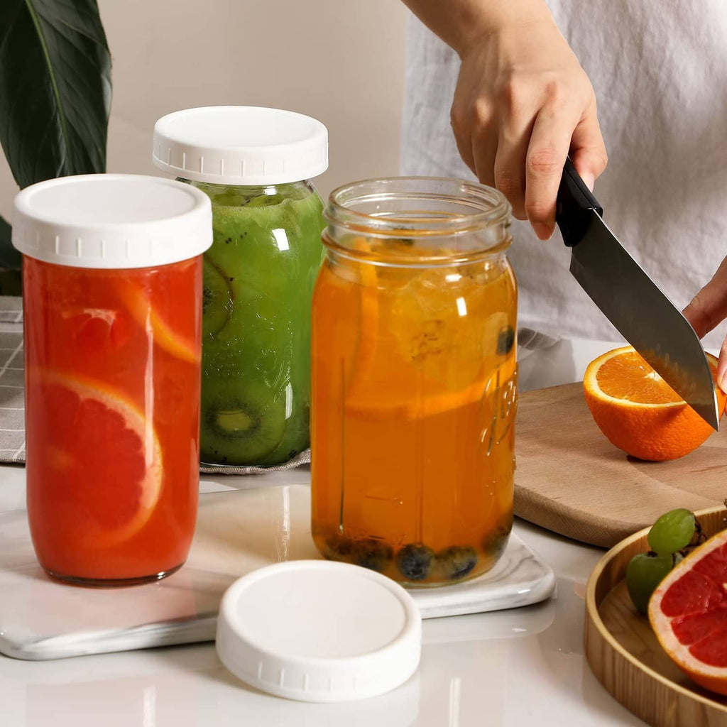 White wide-mouth mason jar lids fitting on jars while prepping citrus drinks