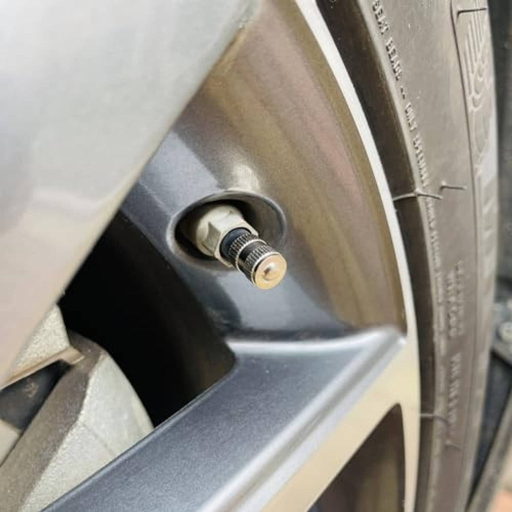 Brass valve stem cap installed on a tire valve stem with rubber gasket