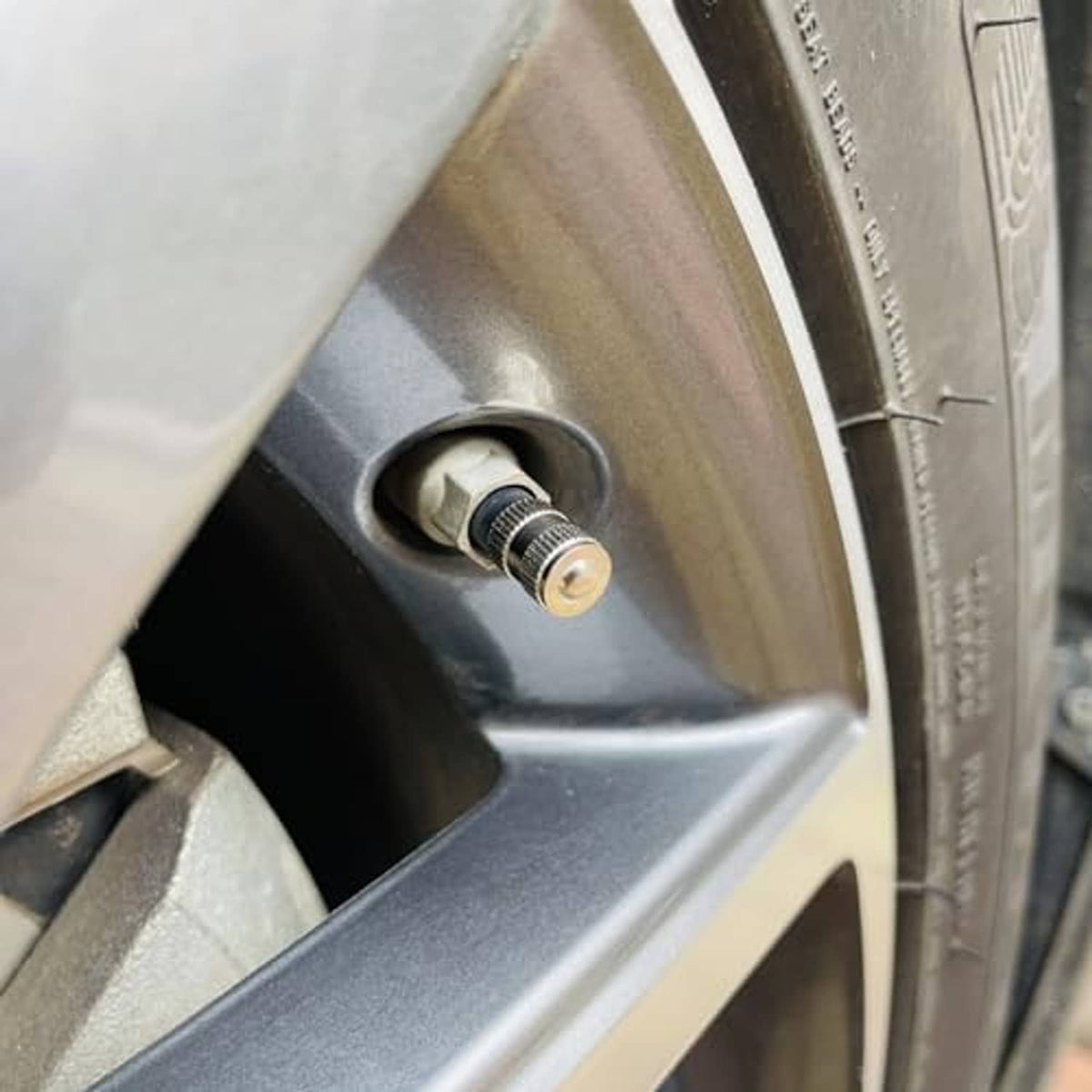 Brass valve stem cap installed on a tire valve stem with rubber gasket