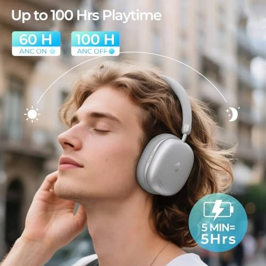 Silver over-ear headphones worn by a person with cushioned earcups and headband