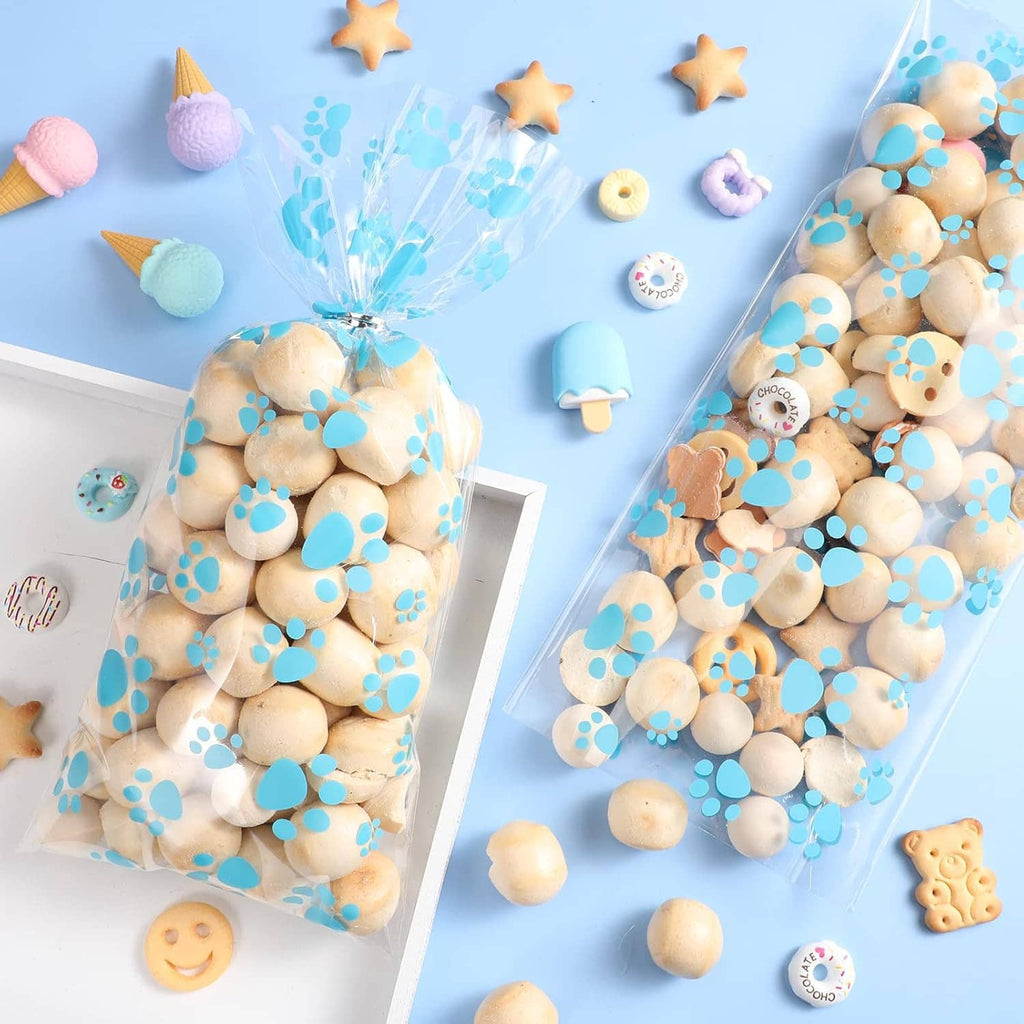 Clear dog treat cellophane bag with blue paw prints filled with round treats, plus another bag.