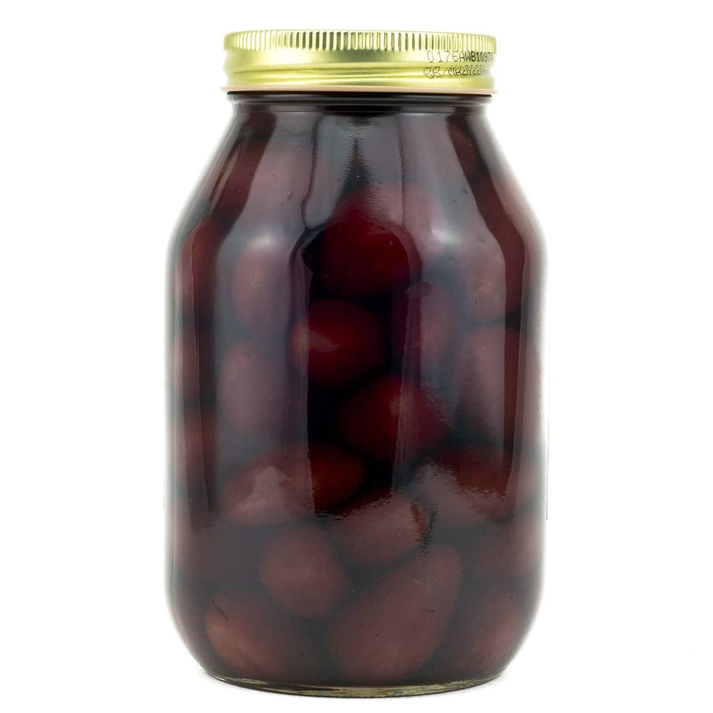 Glass jar of pickled baby beets, dark red whole beets in brine