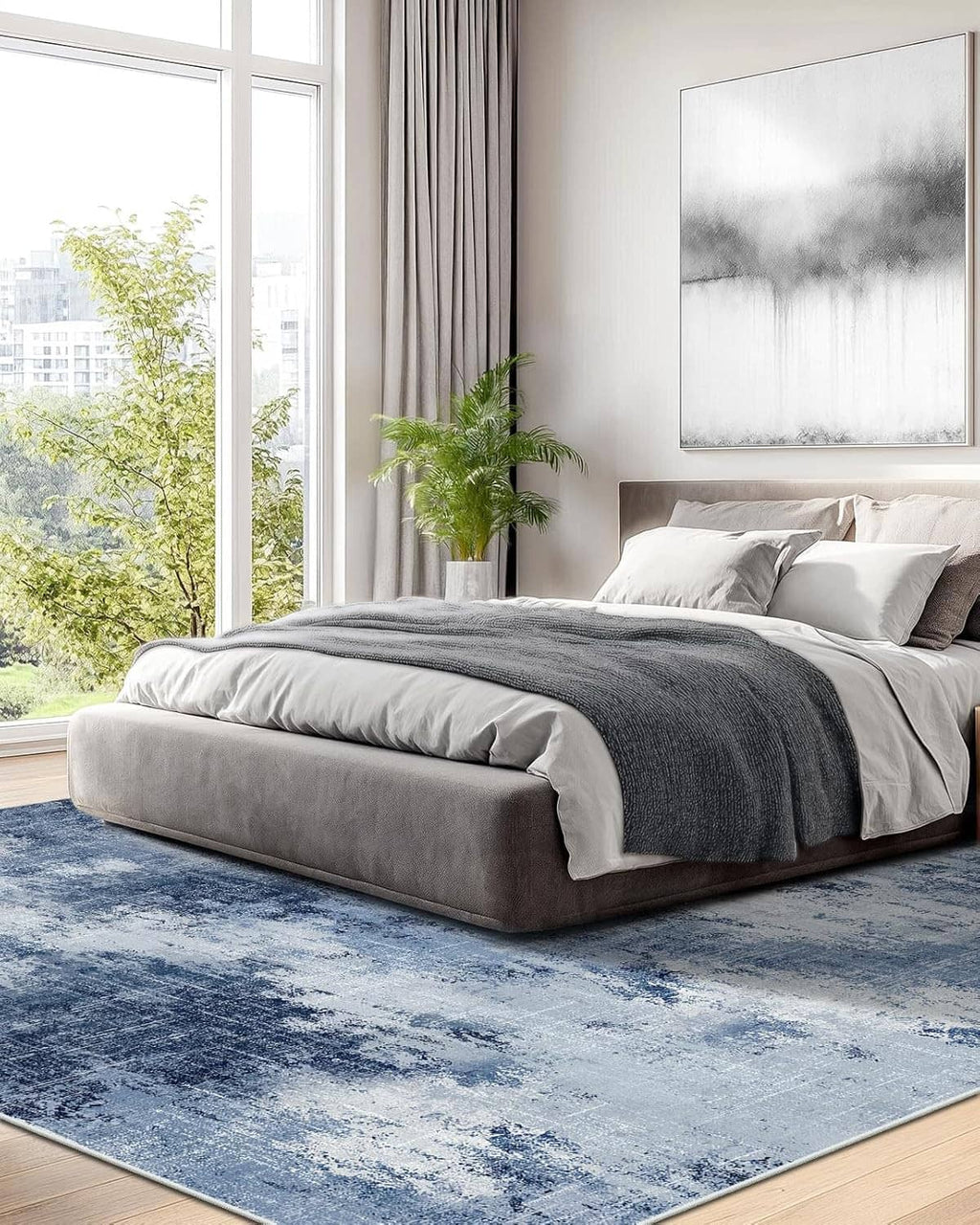 Blue abstract area rug in bedroom under bed with gray bedding