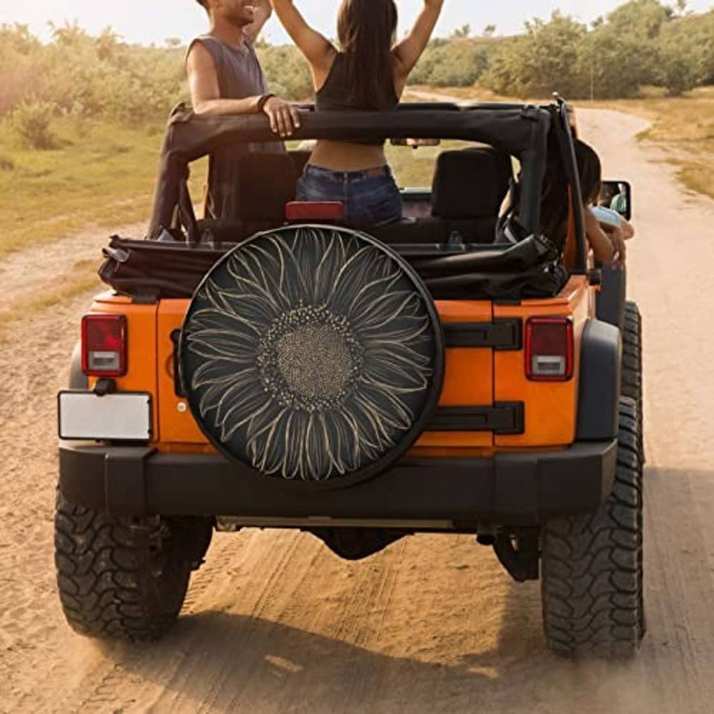 Black spare tire cover with gold sunflower floral design mounted on rear of SUV