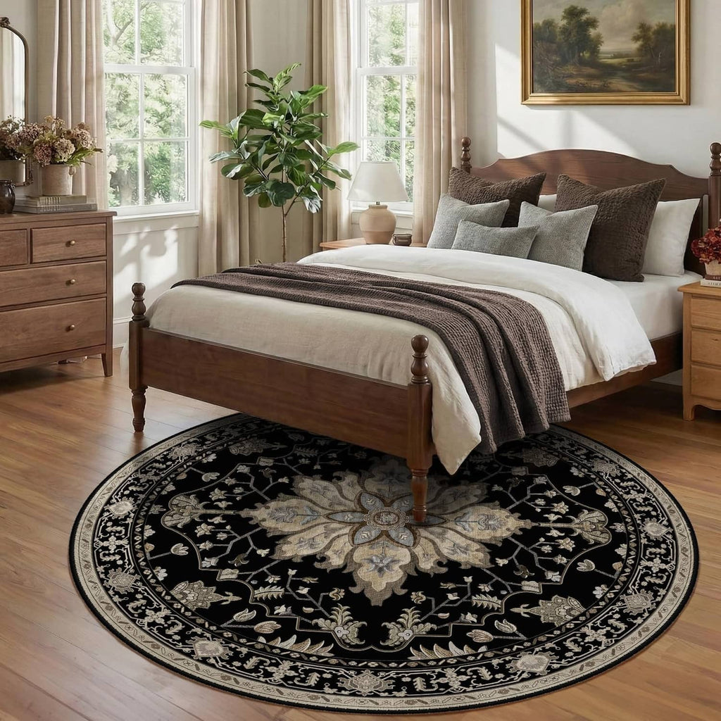 Round black area rug with ornate light centerpiece pattern beneath a bed