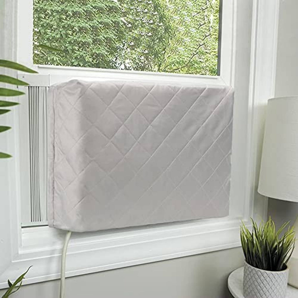 Light gray quilted air conditioner cover draped over window unit