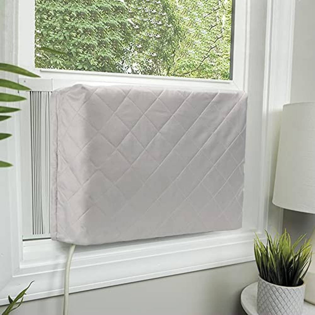 Light gray quilted air conditioner cover draped over window unit