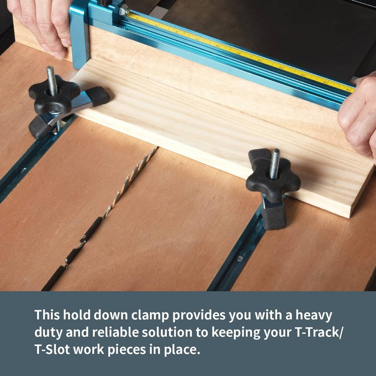 Hands tightening two blue T-track hold-down clamps with black knobs on wood