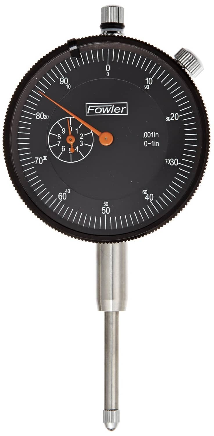 Black dial indicator with orange pointers and engraved 0–1 inch measuring scale