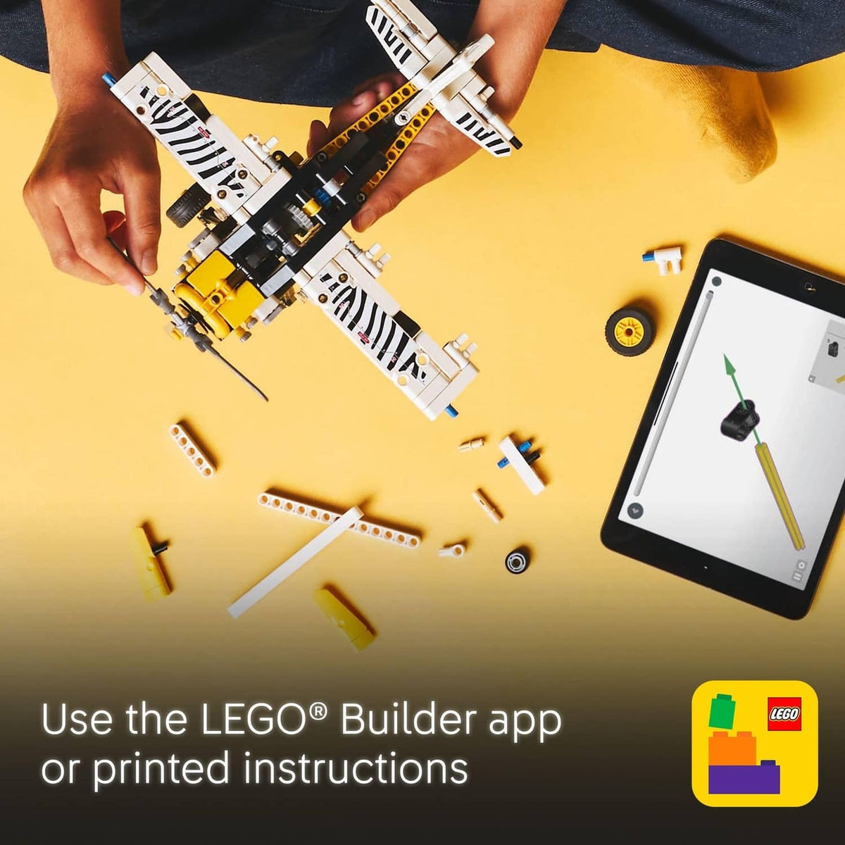 LEGO Technic bush plane toy assembly in progress with hands and loose pieces