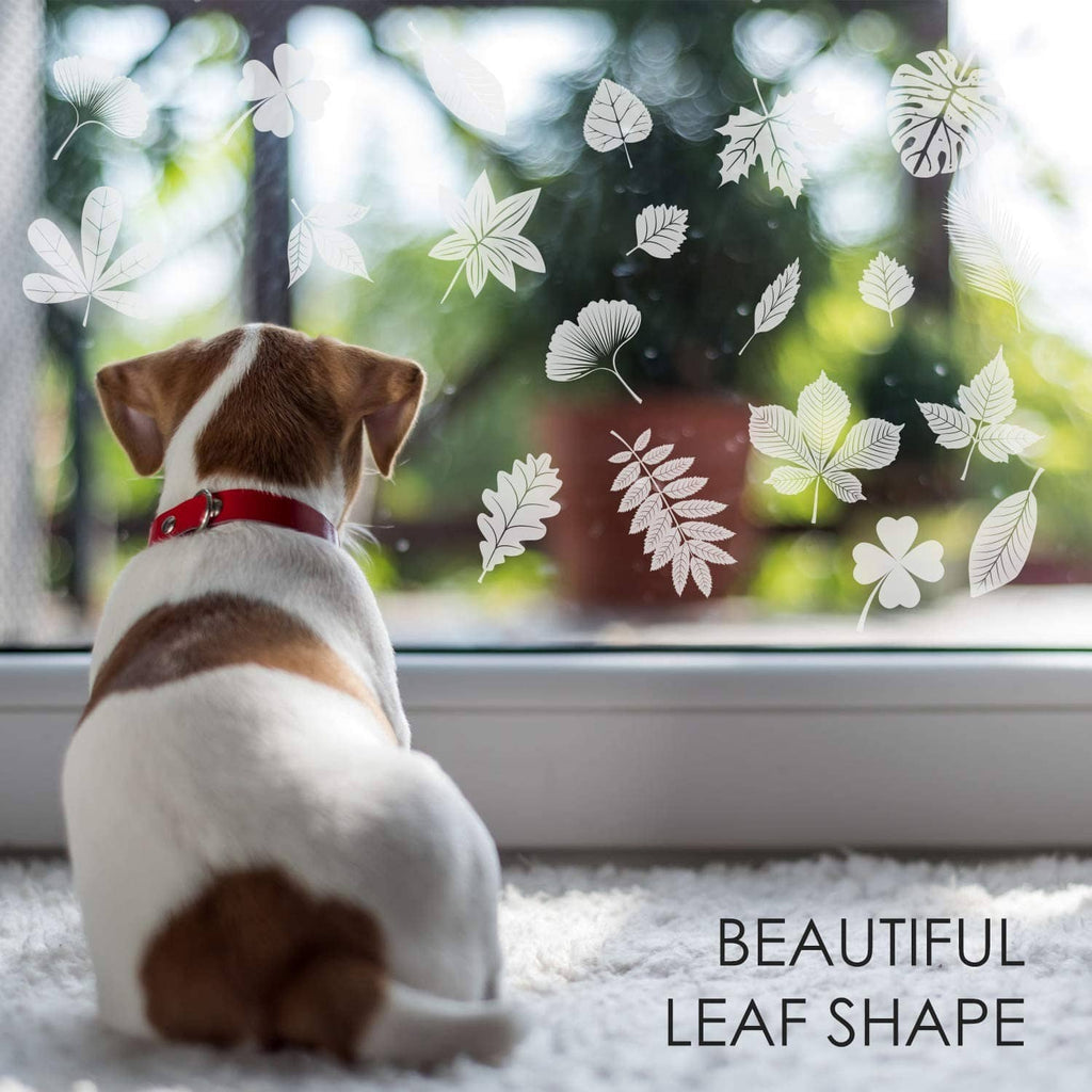 Leaf window cling stickers on glass beside a seated dog, white leaf shapes