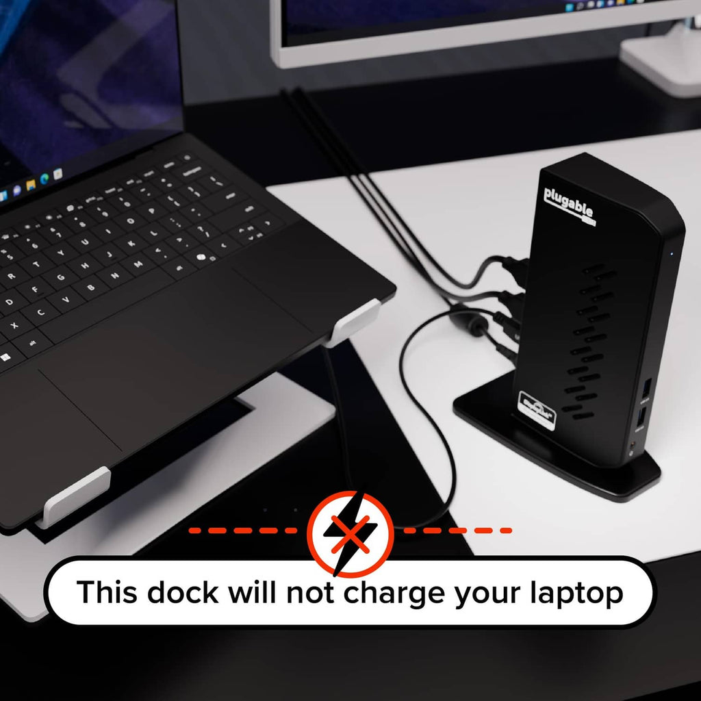 Black docking station with USB cables connected beside laptop keyboard