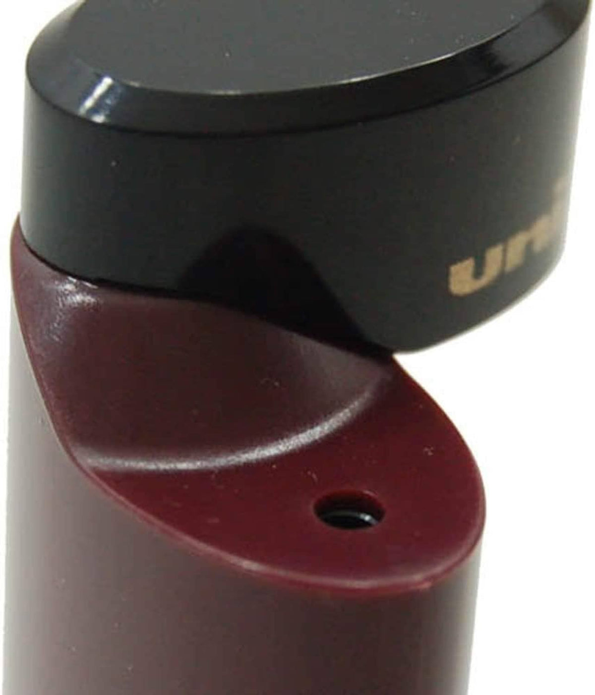 Pocket pencil sharpener close-up with black top and burgundy base with intake hole