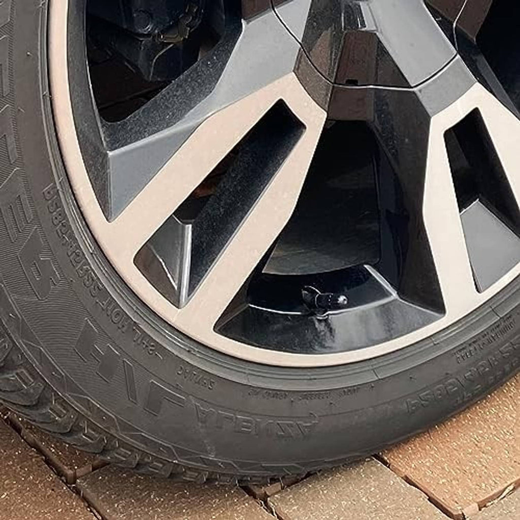 Black long tire valve stem cap installed on a wheel