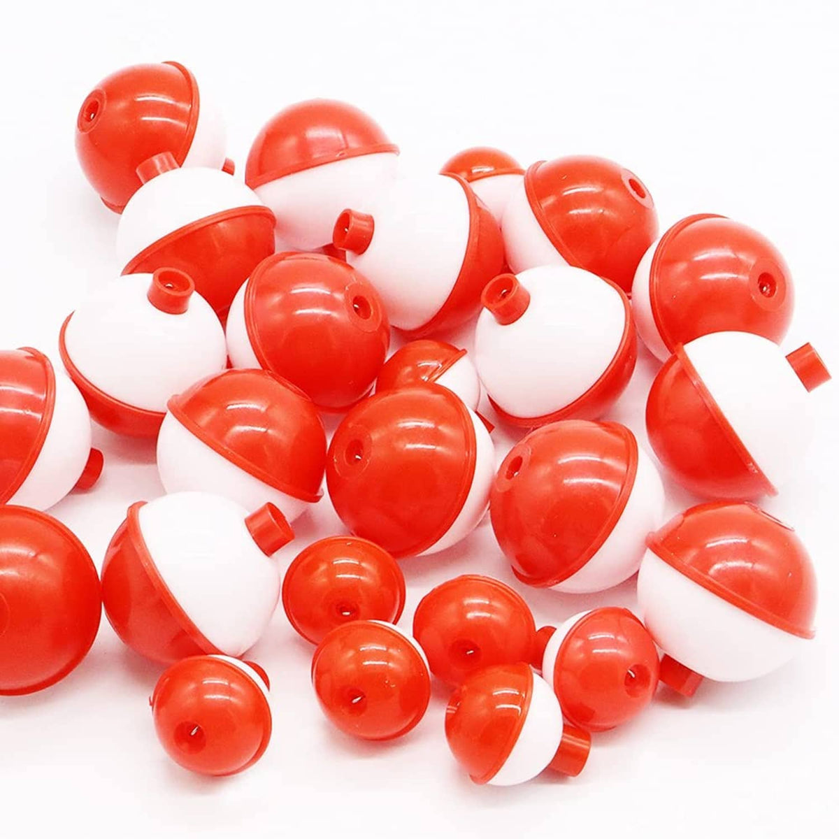 Pile of white-and-red fishing bobbers with hollow stems and red caps