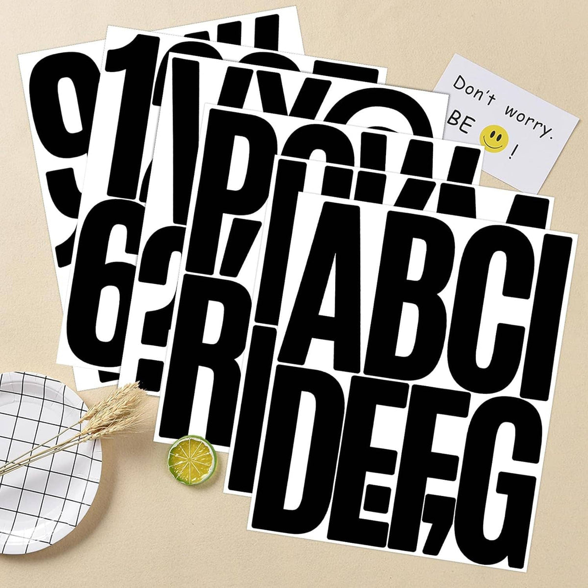 Bold black alphabet and number stickers on a white backing sheet