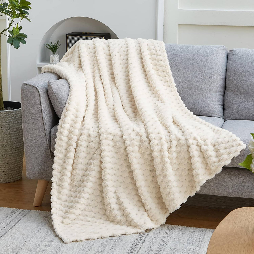 Cream 3D imitation fleece throw blanket draped over gray couch arm