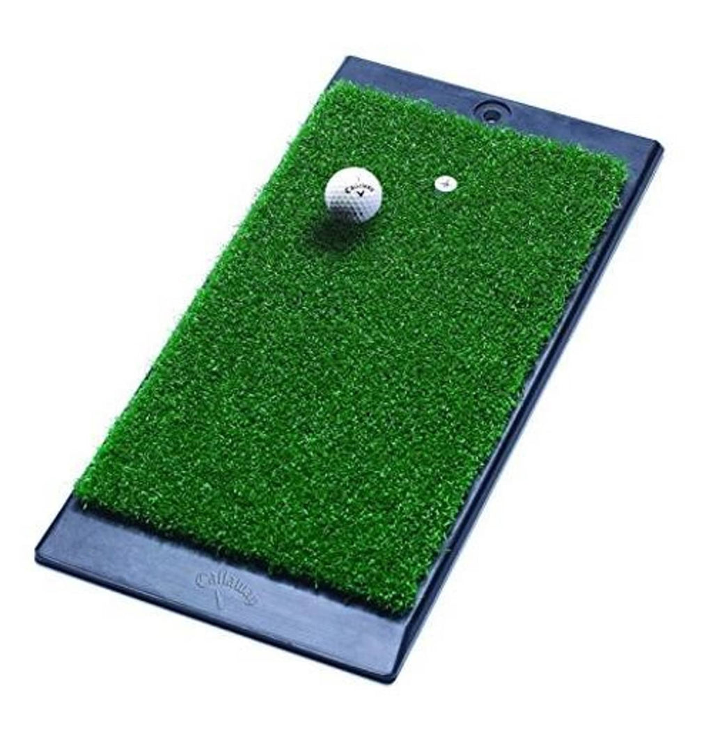 Green turf hitting mat with dark weighted base, golf ball and small target puck