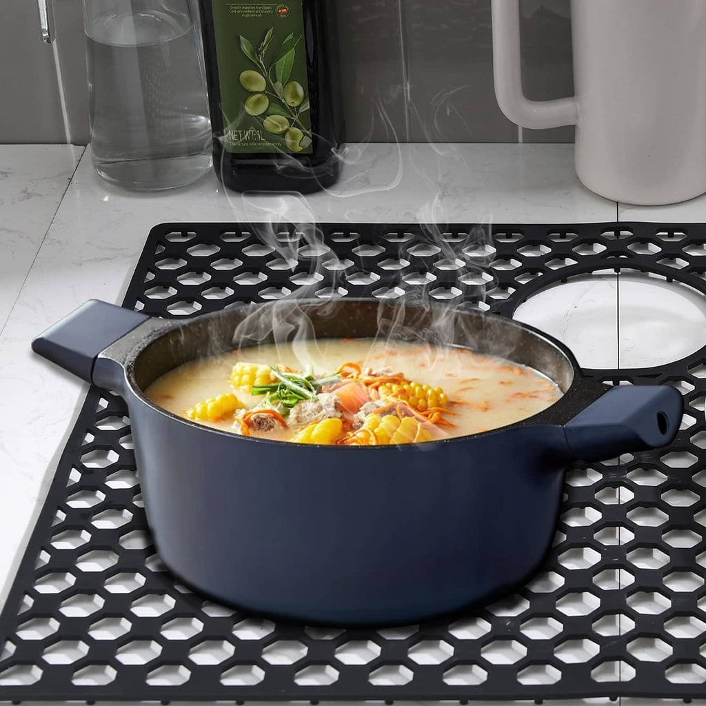 Black silicone sink mat with raised hex pattern under a stockpot and steam