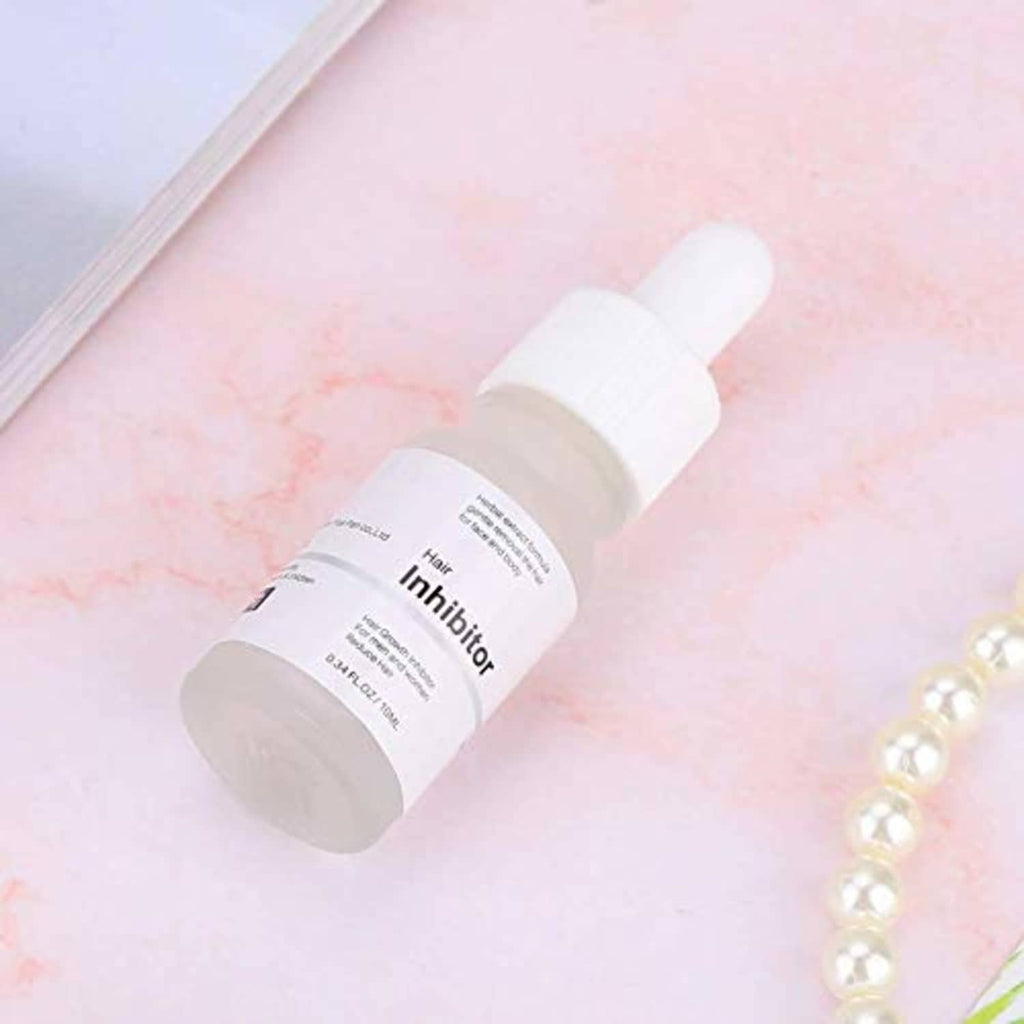 Hair growth inhibitor serum bottle close-up with white dropper cap