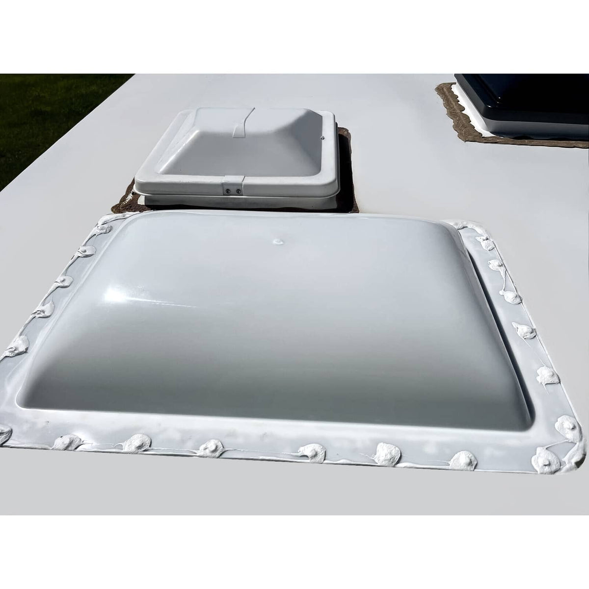White RV skylight cover, 18 x 26 in, with corner clips and mounting screws