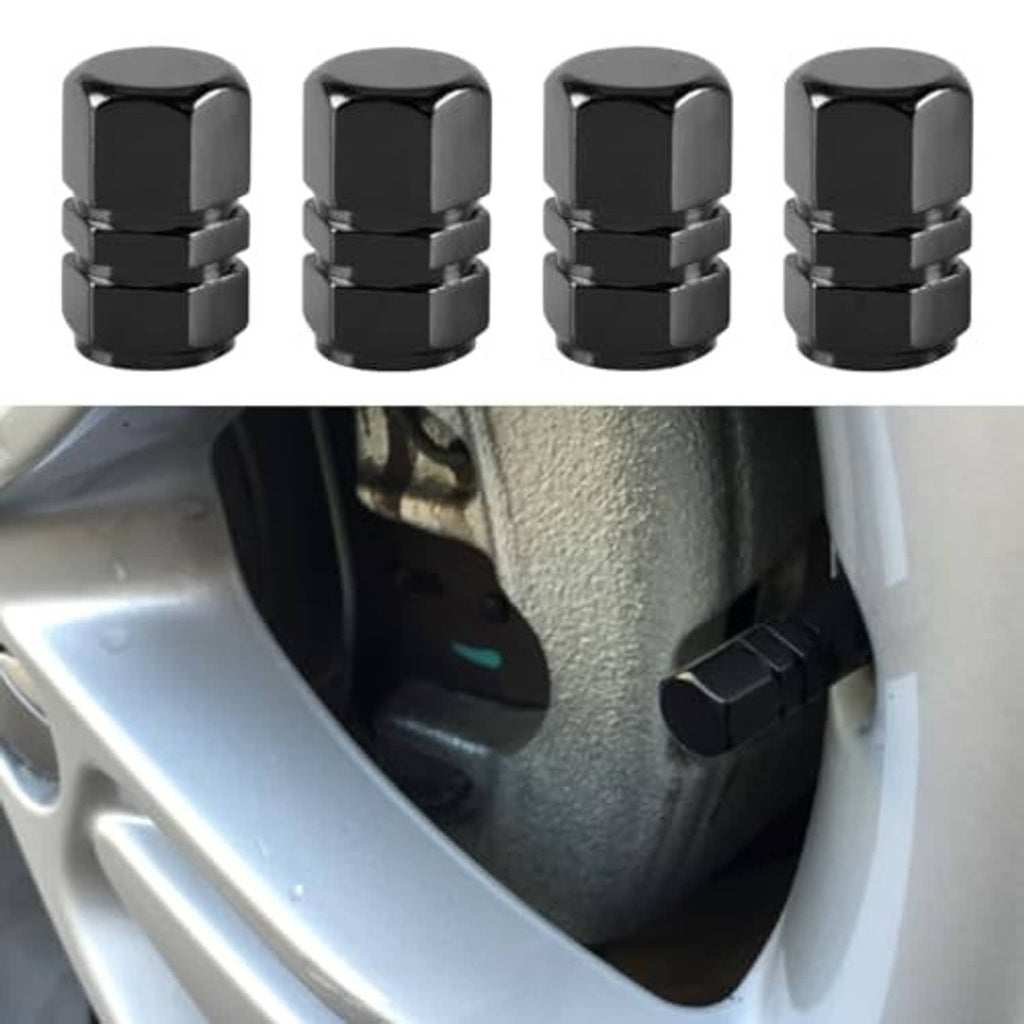 Four black hex tire valve caps beside a car wheel valve stem.