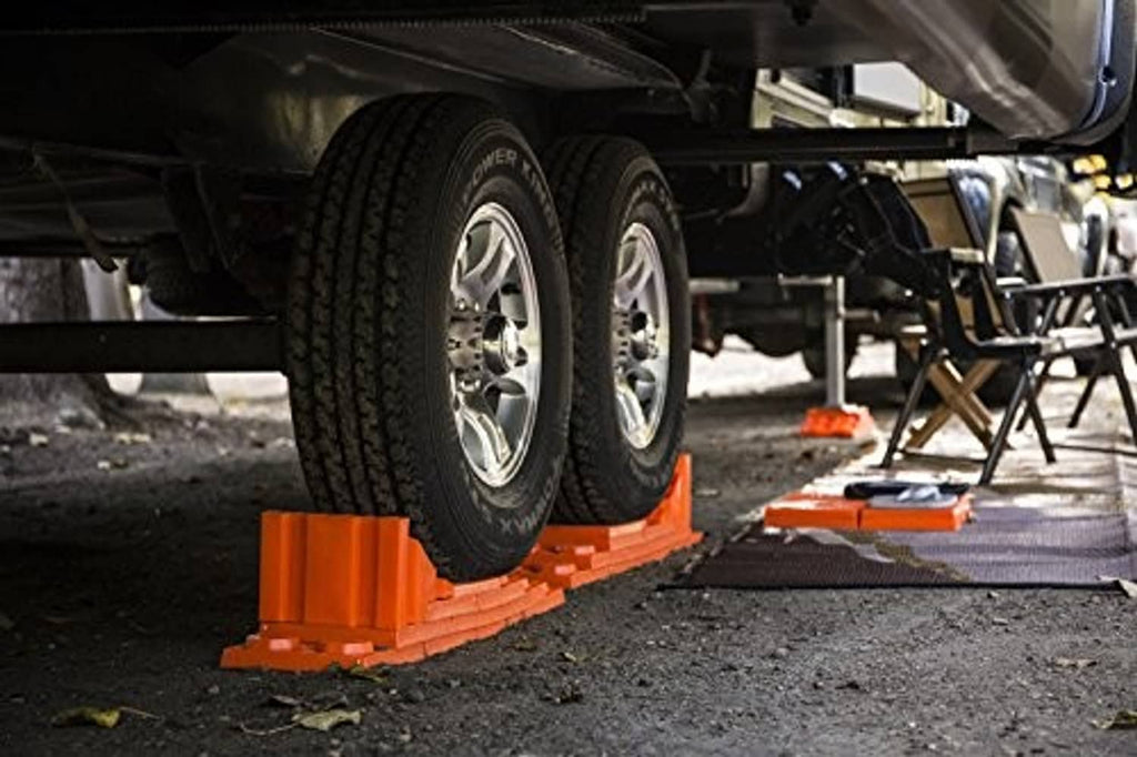Orange vehicle leveling block under tire, with another block nearby